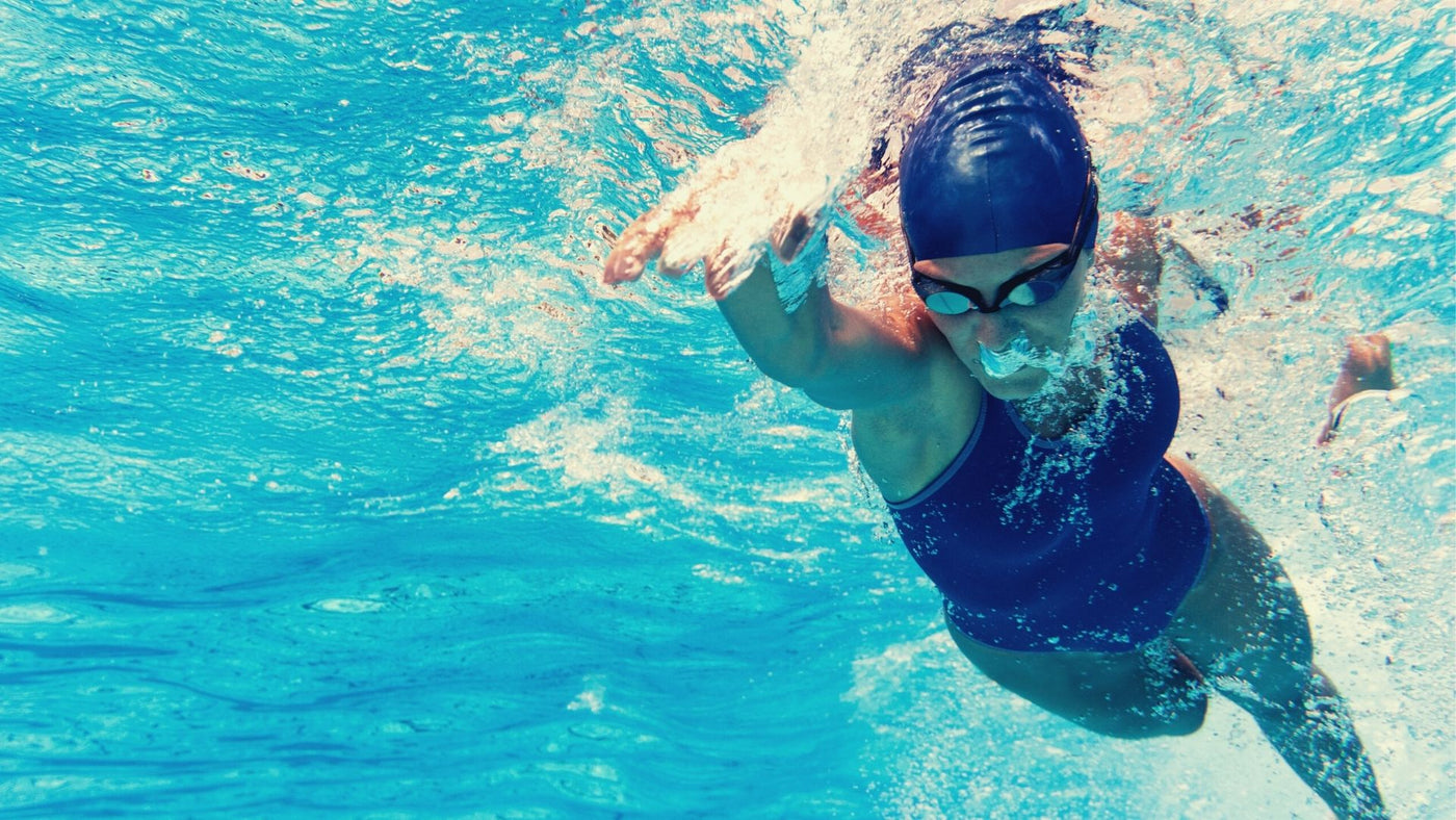 woman swimming in blue cap, and goggles. Endurance Fuel used was Osmocarb™ with her MOXiLyte electrolytes