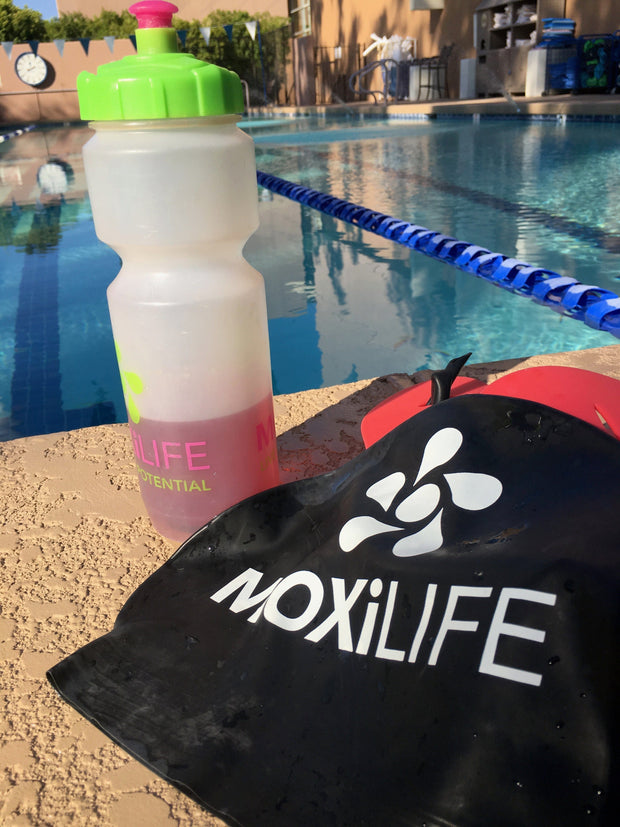MOXiLIFE water bottle and swim cap by the pool